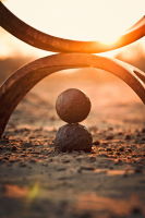 2 pierres empilées sur du sable, sur fond de soleil couchant